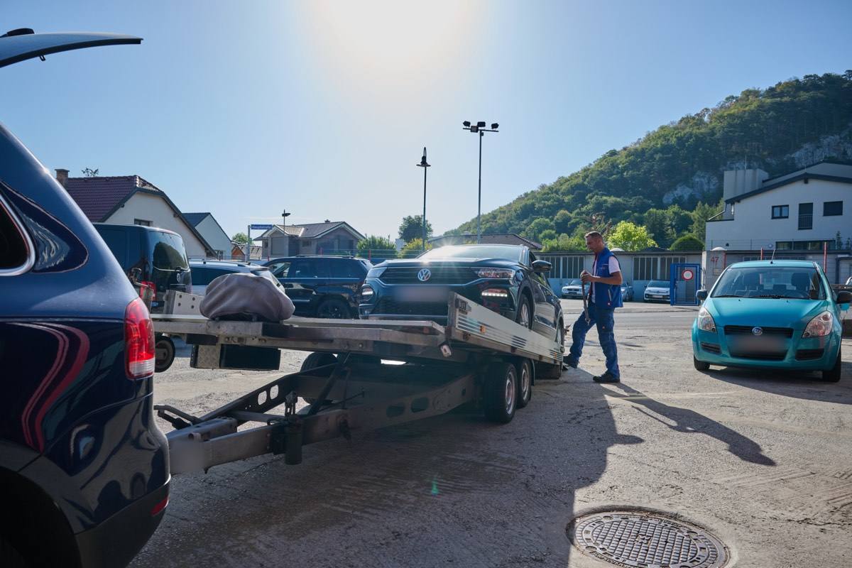 Abschleppanhänger mit Auto vor dem Betrieb in Alland